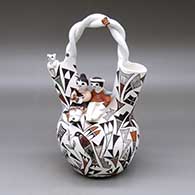 A polychrome wedding vase with a twisted handle,  two children, a cat, bird, butterflies, lady bug and a hummingbird, parrot and geometric design
 by Judy Lewis of Acoma