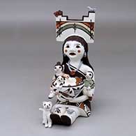 Click for a larger view A sitting grandmother storyteller figure wearing a tablito and holding two children with a cat, butterfly, birds, lady bugs and a pot
by Judy Lewis of Acoma