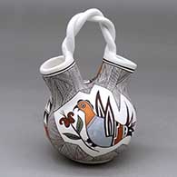 A polychrome wedding vase with a twisted handle and decorated with a parrot, dragonfly, flower, fineline and geometric design
 by Judy Lewis of Acoma