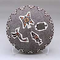 A polychrome seed pot decorated above the shoulder with a hummingbird, butterfly, turtle, fish, fineline and geometric design
 by Rebecca Lucario of Acoma