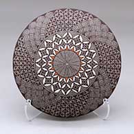 A polychrome seed pot decorated above the shoulder with a North Star, fineline, yucca leaf snowflake and geometric design
 by Rebecca Lucario of Acoma