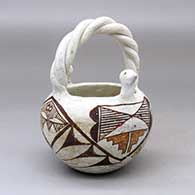 A polychrome basket with bird head appliques on the rim, a twisted handle and decorated with  four panel bird element and geometric design
 by Unknown of Acoma