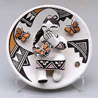 A small plate decorated with a girl and butterfly appliques decorated with geometric designs
 by Marilyn Ray of Acoma