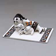 Click for a larger view A tile with appliques of a girl and cat reclining with a butterfly, decorated with a geometric design
by Marilyn Ray of Acoma