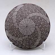 A black on white seed pot decorated on top with a fineline and spiraling geometric design
 by Rebecca Lucario of Acoma