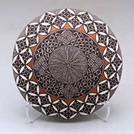 A polychrome seed pot decorated on top with a yucca leaf snowflake, fineline and geometric design
 by Rebecca Lucario of Acoma