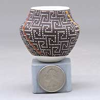 A miniature polychrome jar decorated with a  geometric design built of tiny squares
 by Frederica Antonio of Acoma