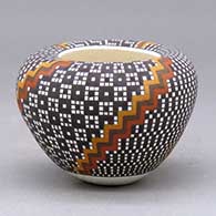A small polychrome jar with an Infinity rim and decorated with a four-panel spiraling geometric design built of tiny colored squares
 by Frederica Antonio of Acoma