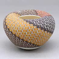 A small polychrome jar with an Infinity rim and decorated with a four-panel spiraling geometric design built of tiny colored squares
 by Frederica Antonio of Acoma
