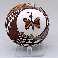 A polychrome seed pot with appliques and painted with a butterfly, lady bug, fineline and geometric design
 by Carolyn Concho of Acoma