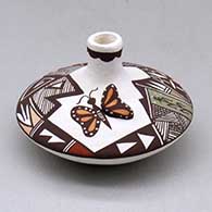 A polychrome seed pot with a short neck and appliques, and painted with a butterfly, lady bug, fineline and geometric design
 by Carolyn Concho of Acoma
