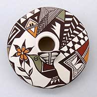 A polychrome seed pot with appliques, and painted with a hummingbird, flower, lady bug, fineline and geometric design
 by Carolyn Concho of Acoma