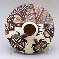 A polychrome seed pot with appliques and painted with a turtle, lady bug, fineline and geometric design
 by Carolyn Concho of Acoma