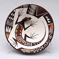 A polychrome plate with appliques and painted with a lizard, lady bug and geometric design
 by Carolyn Concho of Acoma