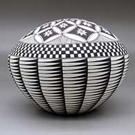 A black on white seed pot decorated with a feather, flower, checkerboard and geometric design, click or tap to see a larger version