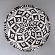 A black on white seed pot decorated with a feather, flower, checkerboard and geometric design, click or tap to see a larger version