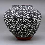 A polychrome jar decorated around the body with a black on white geometric design, click or tap to see a larger version