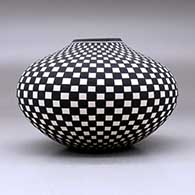 A black on white jar decorated with a checkerboard geometric design, click or tap to see a larger version