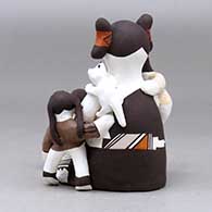 A sitting grandmother storyteller figure with three children, a kitten and a butterfly, click or tap to see a larger version