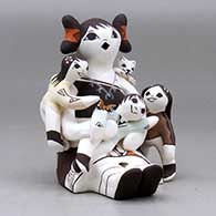 A sitting grandmother storyteller figure with three children, a kitten and a butterfly, click or tap to see a larger version