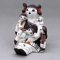 A sitting grandmother storyteller figure with three children, a kitten and a butterfly
 by Judy Lewis of Acoma