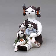 A sitting grandmother storyteller figure with three children, a bird and a butterfly
 by Judy Lewis of Acoma