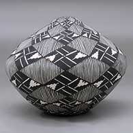 A polychrome seed pot decorated with a fineline, kiva step and geometric design, click or tap to see a larger version