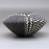 A polychrome seed pot decorated with a checkerboard, fineline and geometric design, click or tap to see a larger version