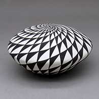 A black on white seed pot decorated with a spiral mesa geometric design, click or tap to see a larger version