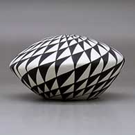 A black on white seed pot decorated with a spiral mesa geometric design, click or tap to see a larger version