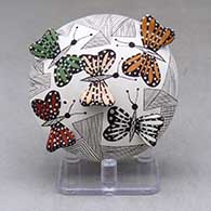 A polychrome seed pot decorated with a fineline and geometric design above the shoulder with butterfly wing appliques on top and on bottom
 by Alisha Sanchez of Acoma