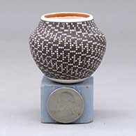 A miniature polychrome jar decorated with a spiraling tiny squares geometric design
 by Frederica Antonio of Acoma