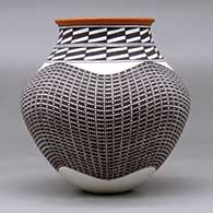 A polychrome jar with a recurved neck and decorated with a tiny squares and geometric design, click or tap to see a larger version