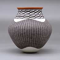 A polychrome jar with a recurved neck and decorated with a tiny squares and geometric design, click or tap to see a larger version