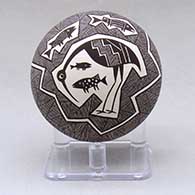 A small black on white seed pot decorated above the shoulder with a cloudeater, fish, fineline and geometric design
 by Rebecca Lucario of Acoma