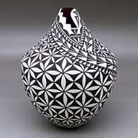 A black on white jar with a kiva step cut opening and decorated with a pumpkin seed snowflake and geometric design
 by Sandra Victorino of Acoma
