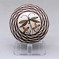 A miniature polychrome seed pot decorated above the shoulder with a dragonfly, flower and geometric design
 by Diane Lewis of Acoma
