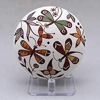 A polychrome seed pot decorated above the shoulder with a dragonfly, plant, flower and geometric design
 by Diane Lewis of Acoma