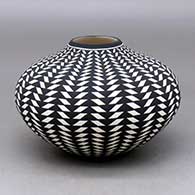A black on white jar decorated with a basket weave geometric design
 by Paula Estevan of Acoma