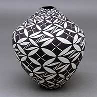 A black on white vase decorated with a spiraling pumpkin seed snowflake and geometric design
 by Sandra Victorino of Acoma