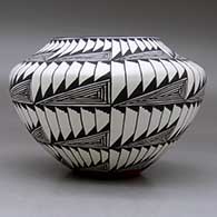 A black on white jar decorated with an eight panel fineline and geometric design, click or tap to see a larger version