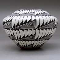 A black on white jar decorated with an eight panel fineline and geometric design, click or tap to see a larger version