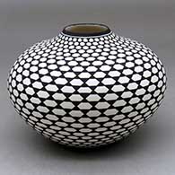 A black on white jar decorated with a stylized butterfly geometric design
 by Paula Estevan of Acoma