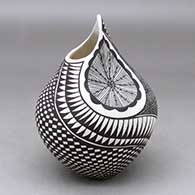 A black on white jar with an organic opening, two indents and decorated with a fineline,checkerboard and geometric design
 by Sandra Victorino of Acoma