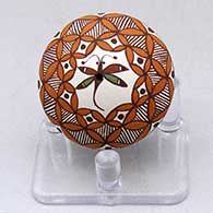 A miniature polychrome seed pot decorated with a dragonfly, pumpkin seed snowflake, fineline and geometric design
 by Diane Lewis of Acoma