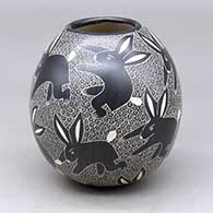 A black on white jar decorated with a sgraffito rabbit and geometric mesh design
 by Alex Ortega of Mata Ortiz and Casas Grandes