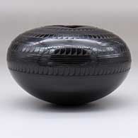 A black on black jar with bands of geometric design and a square opening, click or tap to see a larger version