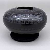 A black on black jar with a square geometric cut opening and a geometric design, click or tap to see a larger version