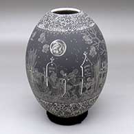 A black-on-white jar decorated with a band of sgraffito Night of the Dead at the Cemetery design between two bands of geometric design
 by Hector Javier Martinez of Mata Ortiz and Casas Grandes