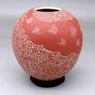 A red-on-white jar decorated with a spiral band of sgraffito butterflies among multiple geometric designs
 by Hector Javier Martinez of Mata Ortiz and Casas Grandes